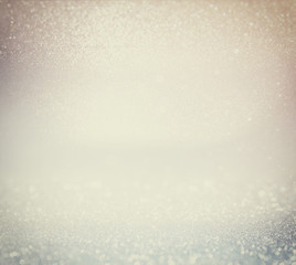 glitter vintage lights background. gold, silver, and white. de-focused.
