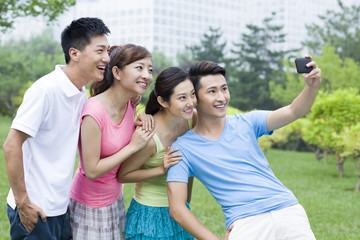 Cheerful young friends taking self portrait shot with smart phone