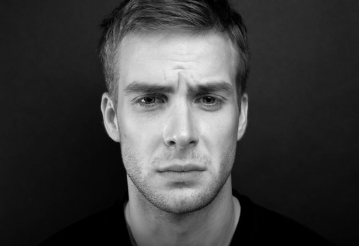 Black and white portrait photo of young man with sad look in v n
