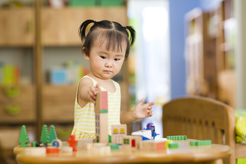 Little girl playing with toys at home