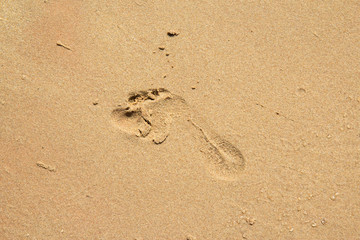 Fototapeta na wymiar Child foot step on sand