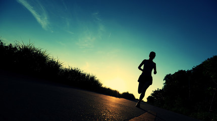 young woman runner running on sunrise seaside