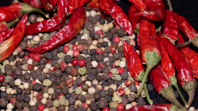 Pile of multi color peppercorns and dried chili, rotating