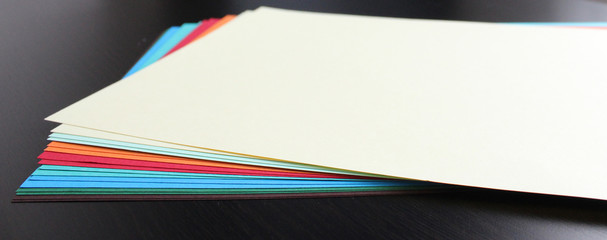 Still life image of colored craft papers on a dark background