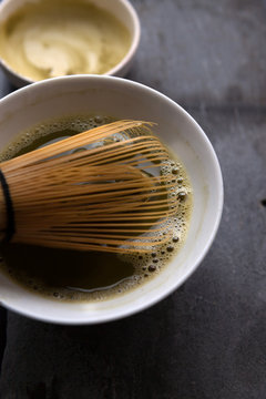 Close up of the bowl of fresh matcha tea with bamboo whisk