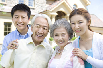 Family of four in front of house