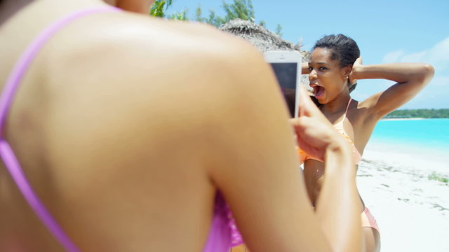 African American and Asian Chinese girls taking selfie on beach vacation