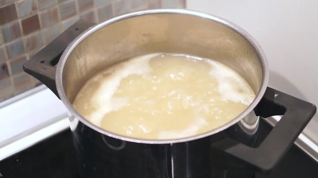 Boiling pasta in pot at ceramic stove