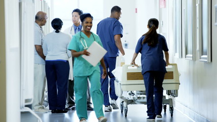 Positive multi ethnic team of hospital staff work and consult with senior couple - Powered by Adobe