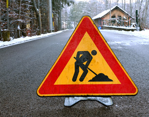 road sign work in progress in the road with silhouette of man wo