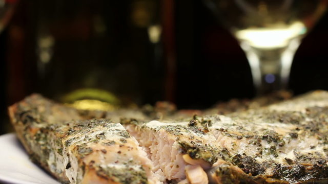 Baked salmon fish with aromatic herbs crust and wine, rotating