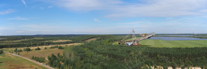 Obraz premium Sonnenkraft statt Braunkohle, Braunkohlebagger im Lausitzer Seenland, Solarfelder im Hintergrund