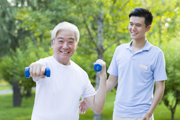 Senior man exercising with dumbbell in nursing home