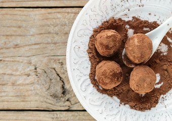 Homemade chocolate truffles with cocoa powder on a white plate