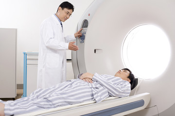  Medical professional helping a patient into a MRI scanner
