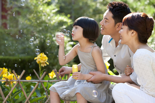 Family blowing Bubbles in garden