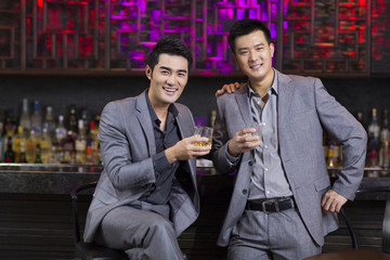 Male friends having drinks at bar
