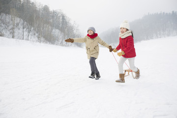 Fototapeta na wymiar Happy children running with sled on the snow
