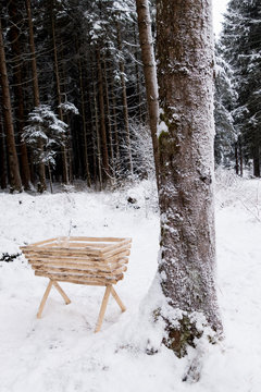 Mangiatoia a rastrelliera in legno per ungulati in un bosco innevato 