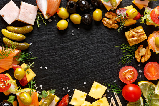 Set of different tasty appetizers, snacks  and ingredients on a black background