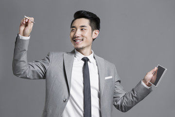 Happy young businessman using digital tablet