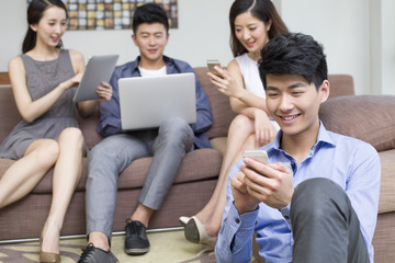 Fototapeta premium Happy young friends with smart phones and laptop