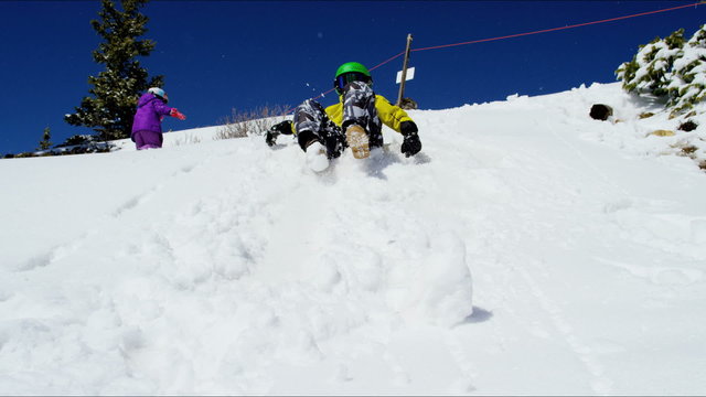 Caucasian young boy girl child colourful clothes outdoor fun playing snow Aspen