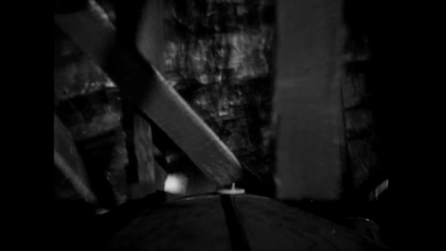 Man crashing pick-up truck through barn door, 1940s