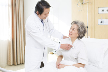 Obraz premium Doctor using stethoscope on patient in hospital