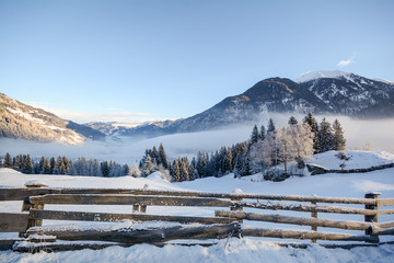View to a winter landscape with wooden fence, Gasteinertal valley near Bad Gastein, Pongau Alps -...