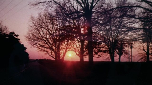 Dissolve shot of  Rolls Royce driving through beautiful sunset
