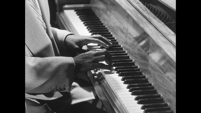 Medium shot of jazz musician playing piano, 1950s