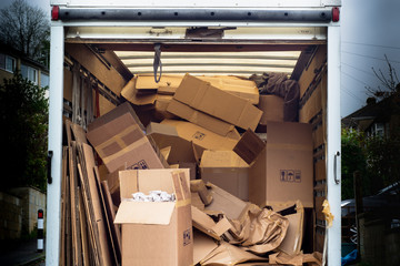 Removal van with untidy boxes dumped inside. A removal lorry is filled with carelessly thrown...