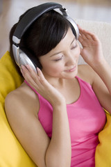Naklejka premium Asian woman listening to music