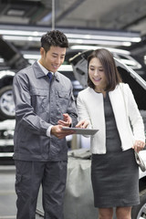 Auto mechanic talking with car owner