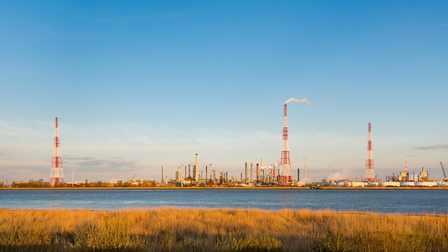 Timelapse sequence of a large oil refinery in the harbor of Antwerp, Belgium with blue sky and warm evening light in 4K.