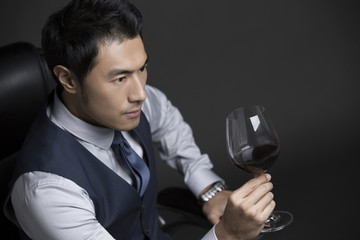Confident businessman enjoying red wine