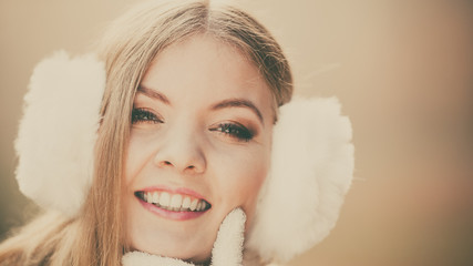 Portrait of pretty smiling woman in white earmuffs