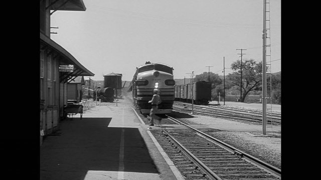 Man crossing railroad tracks in front of train
