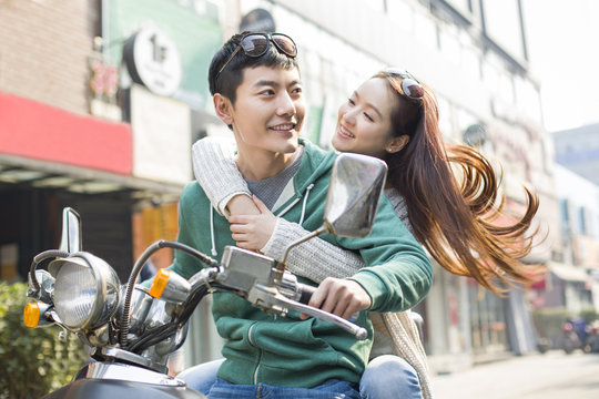 Young couple riding motorcycle together