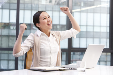 Businesswoman with arms raised in celebration
