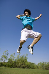 Young man jumping in air at park