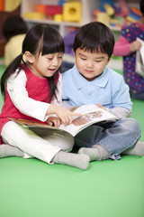 Cute little girl and little boy reading books