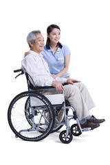 Female nursing assistant taking care of senior in wheelchair