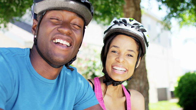 Portrait of young fit African American couple cycling to keep healthy outdoors