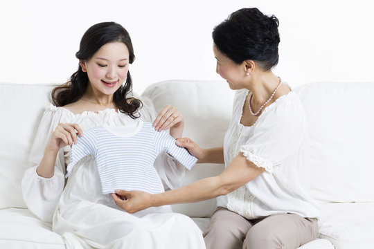 Mother and daughter preparing baby clothing