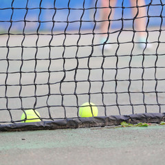 Tennis balls lies near the tennis net