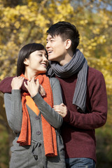 Fototapeta premium Happy young couple in love arm around outdoors in autumn