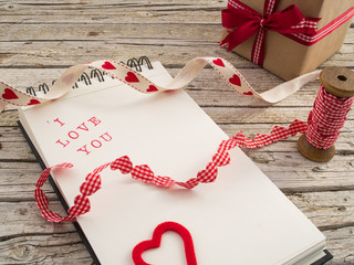 gift, ribbon and notebook with I love you