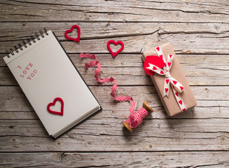 valentine gift box, ribbon, notebook and red heart shape tag on